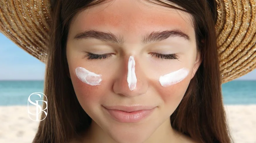 Hermosa mujer da tratamientos a su rostro para prevenir las manchas en la piel provocadas por el sol.